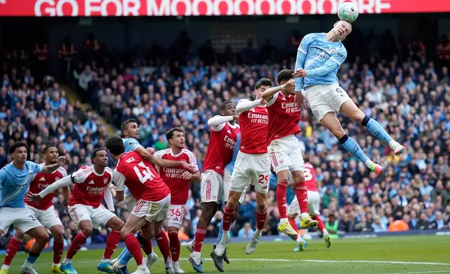 Manchester City's Erling Haaland heads the ball during the English Premier League soccer match between Manchester City and and Arsenal, in Manchester, England, Sunday, April 19, 2026. (AP Photo/Dave Thompson)