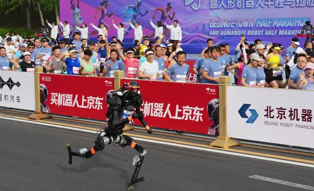 A robot starts off for the Beijing E-Town Half Marathon and Humanoid Half Marathon on the outskirts of Beijing on Sunday, April 19, 2026. (AP Photo/Ng Han Guan)