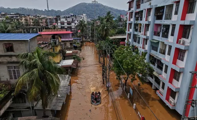 State Deserter Response Force (SDRF) personnel travel on a boat headed to rescue affected people after a pre monsoon heavy rain on a flooded road in Guwahati, India, Monday, April 20, 2026. (AP Photo/Anupam Nath)