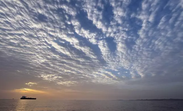 The sun rises behind a tanker anchored in the Strait of Hormuz off the coast of Qeshm Island, Iran, Saturday, April 18, 2026. (AP Photo/Asghar Besharati)