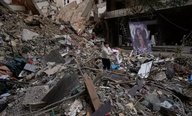 A boy holds his school book found amongst the rubble of a destroyed building, following a ceasefire between Hezbollah and Israel, in Dahiyeh, Beirut's southern suburbs, Lebanon, Monday, April 20, 2026. (AP Photo/Hussein Malla)