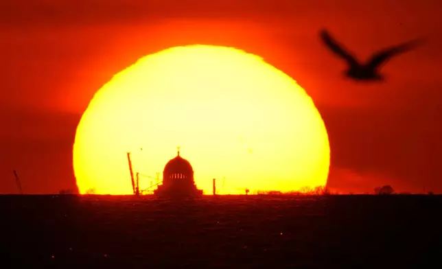 The sun sets behind St. Nicholas Naval Cathedral located on Kronstadt Island in the Gulf of Finland, outside St. Petersburg, Russia, Sunday, April 19, 2026. (AP Photo/Dmitri Lovetsky)