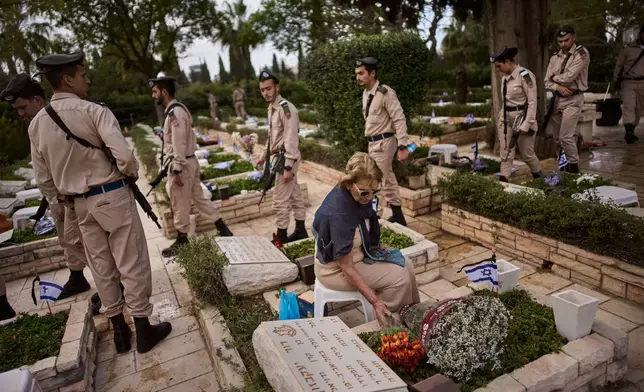 Israeli soldiers and relatives visit a military cemetery ahead of the annual Memorial Day honoring fallen soldiers and victims of nationalistic attacks in Tel Aviv, Israel, Monday, April 20, 2026. (AP Photo/Oded Balilty)