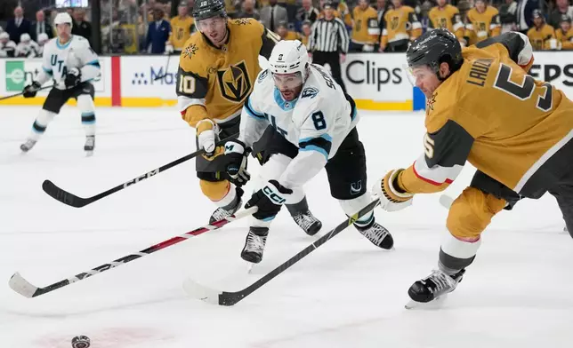 Utah Mammoth center Nick Schmaltz (8) and Vegas Golden Knights defenseman Jeremy Lauzon (5) battle for the puck during the third period in Game 1 of a first-round NHL hockey Stanley Cup playoff series Sunday, April 19, 2026, in Las Vegas. (AP Photo/John Locher)
