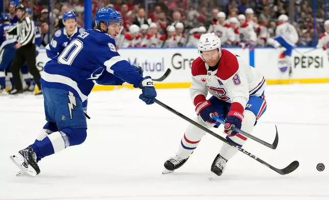 Tampa Bay Lightning defenseman J.J. Moser (90) knocks the puck away from Montréal Canadiens defenseman Mike Matheson (8) during the first period in Game 1 of an NHL hockey Stanley Cup first-round playoff series, Sunday, April 19, 2026, in Tampa, Fla. (AP Photo/Chris O'Meara)
