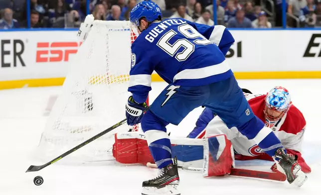 Tampa Bay Lightning center Jake Guentzel (59) chases the puck after a save by Montréal Canadiens goaltender Jakub Dobes (75) during the second period in Game 2 of an NHL hockey Stanley Cup first-round playoff series, Tuesday, April 21, 2026, in Tampa, Fla. (AP Photo/Chris O'Meara)