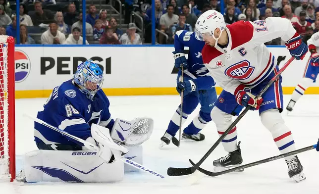 Montréal Canadiens center Nick Suzuki (14) deflects the puck on Tampa Bay Lightning goaltender Andrei Vasilevskiy (88) during the first period in Game 2 of an NHL hockey Stanley Cup first-round playoff series, Tuesday, April 21, 2026, in Tampa, Fla. (AP Photo/Chris O'Meara)