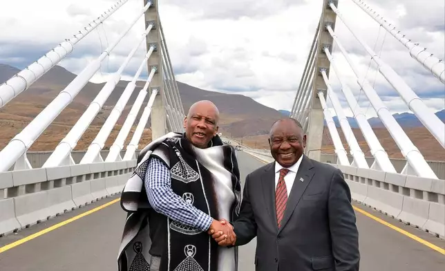 In this photo provided by the South African Government Communications and Information Services (GCIS), King of Lesotho Letsie III, left, shakes hand with South African President Cyril Ramaphosa following the official opening of the Senqu Bridge in Mokhotlong, Lesotho, Wednesday, April 22, 2026. (Elmond Jiyane/South African Government Communication and Information Services via AP)