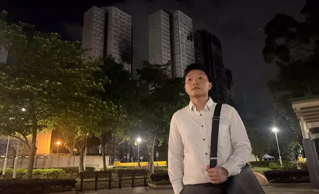 Resident Cyrus Ng poses for photos at a park near Wang Fuk Court, the apartment complex hit by Hong Kong's deadliest fire in decades, Monday, April 13, 2026. (AP Photo/Kanis Leung)