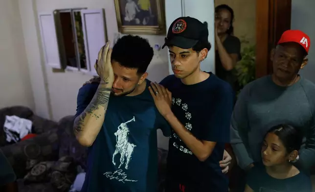 FILE - Arturo Suárez, left, a musician, one of the Venezuelan migrants deported months ago to El Salvador by the United States under the U.S. President Donald Trump administration's immigration crackdown, reacts as he returned home and was welcomed by his relatives, in Caracas, Venezuela, July 22, 2025. (AP Photo/Cristian Hernandez, File)
