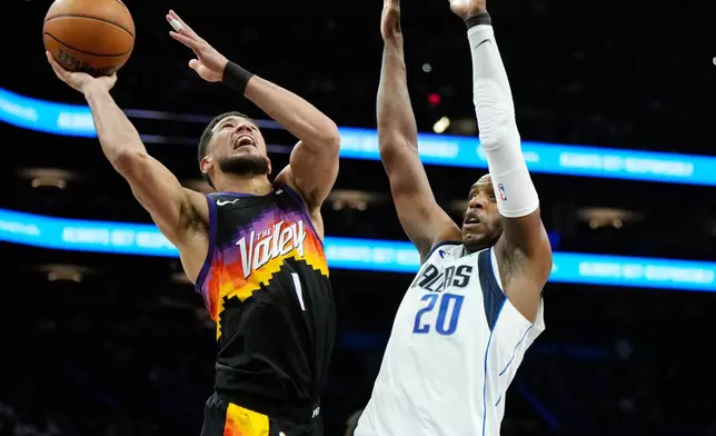 Phoenix Suns guard Devin Booker (1) gets off a shot against Dallas Mavericks forward Khris Middleton (20) during the first half of an NBA basketball game, Wednesday, April 8, 2026, in Phoenix. (AP Photo/Ross D. Franklin)