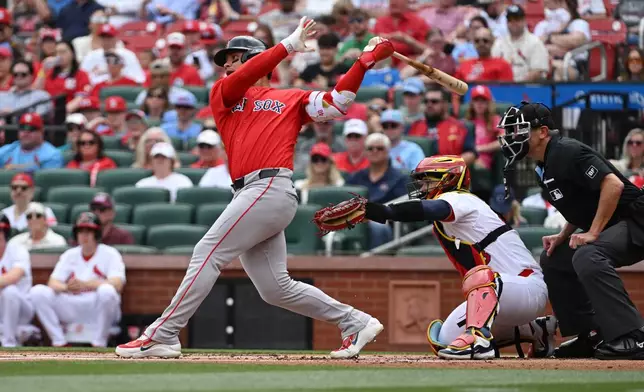 Boston Red Sox's Willson Contreras, left, hits a two-run home run in the first inning of a baseball game St. Louis Cardinals, Sunday, April 12, 2026, in St. Louis. (AP Photo/Michael Thomas)