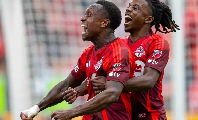 Toronto FC defender Richie Laryea, left, is congratulated by teammate Malik Henry after scoring a goal againt Austin FC during the second half of an MLS soccer game in Toronto, Saturday, April 18, 2026. (Frank Gunn/The Canadian Press via AP)