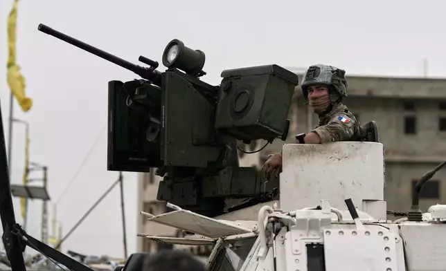 A French U.N peacekeeper sits on an armored personnel carrier at a road used by displaced people to return to their villages on the second day of a ceasefire between Hezbollah and Israel in Qasmiyeh, near Tyre city, southern Lebanon, Saturday, April 18, 2026. (AP Photo/Bilal Hussein)