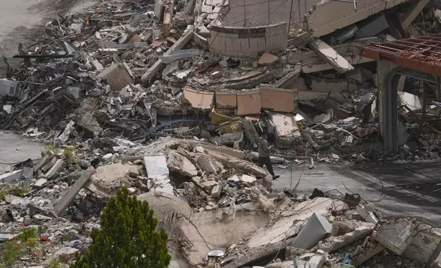 A man walks between destroyed buildings on the second day of a ceasefire between Hezbollah and Israel in Nabatiyeh town, south Lebanon, Saturday, April 18, 2026.(AP Photo/Mohammed Zaatari)
