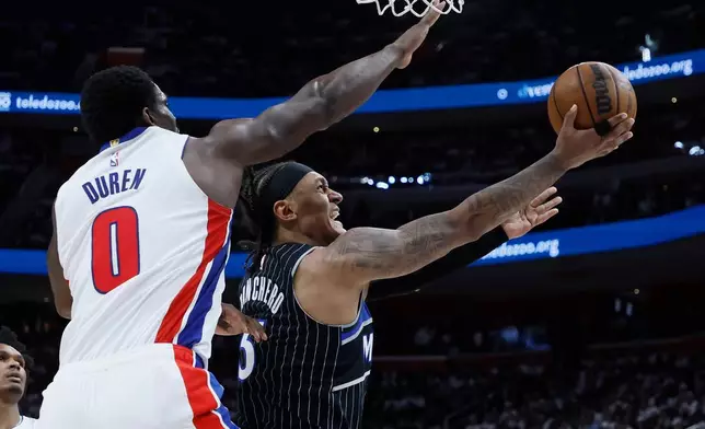 Orlando Magic forward Paolo Banchero (5) lays up a shot against Detroit Pistons center Jalen Duren (0) during the second half in Game 2 of a first-round NBA basketball playoffs series Wednesday, April 22, 2026, in Detroit. (AP Photo/Duane Burleson)