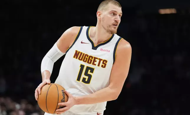Denver Nuggets center Nikola Jokic (15) handles the ball during the first half in Game 3 of a first-round NBA basketball playoff series against the Minnesota Timberwolves, Thursday, April 23, 2026, in Minneapolis. (AP Photo/Abbie Parr)
