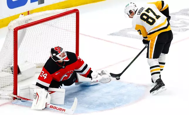 New Jersey Devils goaltender Jake Allen (34) defends against a shot by Pittsburgh Penguins center Sidney Crosby (87) during the third period of an NHL hockey game, Thursday, April 9, 2026, in Newark, N.J. (AP Photo/Noah K. Murray)