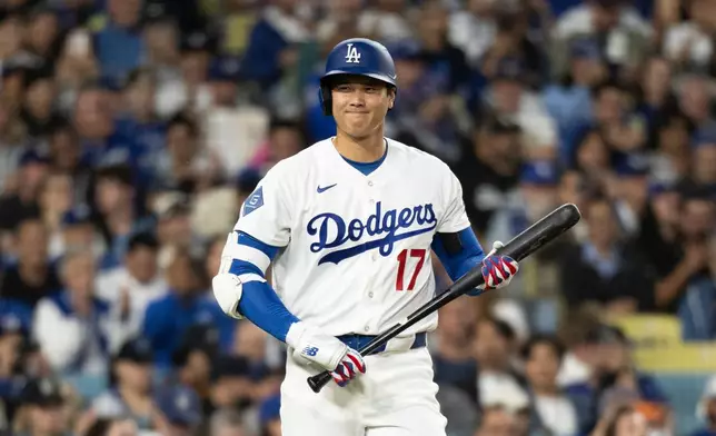 Los Angeles Dodgers' Shohei Ohtani smiles towards the Cleveland Guardians dugout during the first inning of a baseball game in Los Angeles, Tuesday, March 31, 2026. (AP Photo/Kyusung Gong)