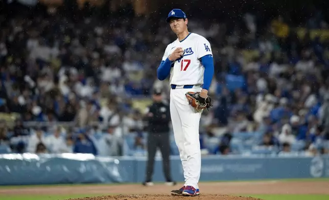 Los Angeles Dodgers starting pitcher Shohei Ohtani gestures to Cleveland Guardians' Angel Martínez after Martínez got hit by a pitch during the fifth inning of a baseball game in Los Angeles, Tuesday, March 31, 2026. (AP Photo/Kyusung Gong)