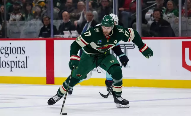 Minnesota Wild's Marcus Foligno (17) controls the puck against the Seattle Kraken during the third period of an NHL hockey game Tuesday, April 7, 2026, in St. Paul, Minn. (AP Photo/Lily Dozier)