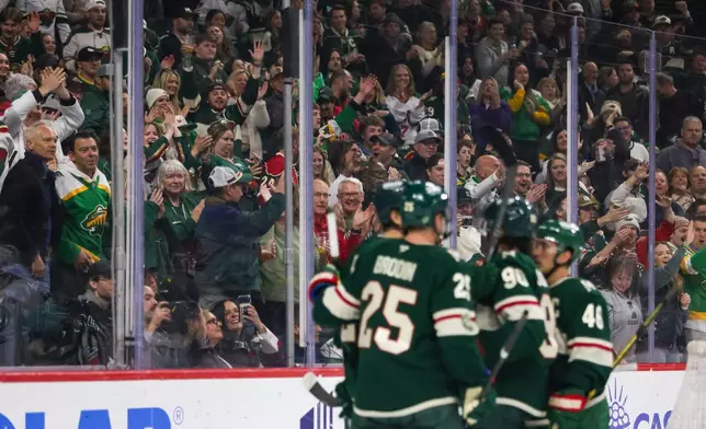 Minnesota Wild fans celebrate a goal against the Seattle Kraken during the first period of an NHL hockey game Tuesday, April 7, 2026, in St. Paul, Minn. (AP Photo/Lily Dozier)