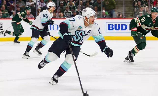Seattle Kraken's Jaden Schwartz (17) controls the puck against the Minnesota Wild during the first period of an NHL hockey game Tuesday, April 7, 2026, in St. Paul, Minn. (AP Photo/Lily Dozier)