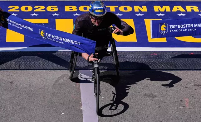 Marcel Hug, of Switzerland, breaks the tape to win the men's wheelchair division at the Boston Marathon, Monday, April 20, 2026, in Boston. (AP Photo/Charles Krupa)