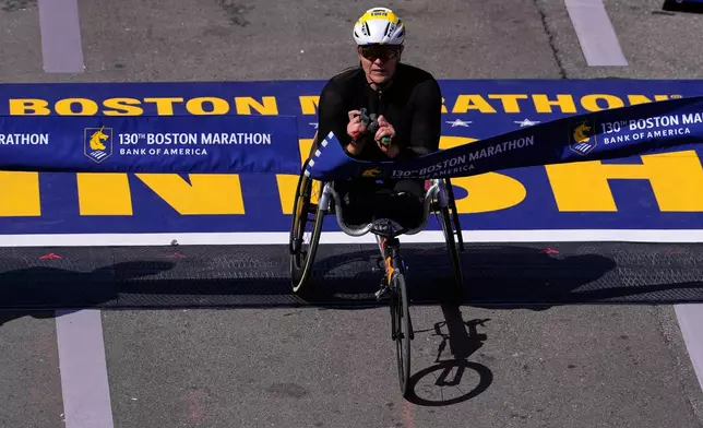 Eden Rainbow-Cooper, of Portsmouth, England, breaks the finish line tape to win the women's wheelchair division of the Boston Marathon, Monday, April 20, 2026, in Boston. (AP Photo/Charles Krupa)