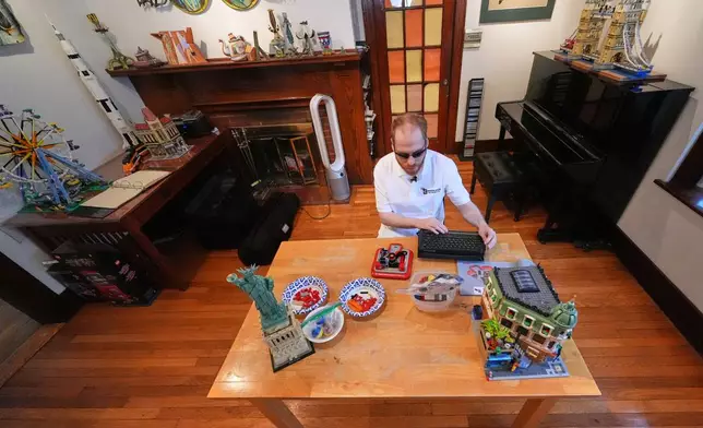 Matthew Shifrin, the founder of Bricks for the Blind, reads from a braille terminal while building a LEGO project at his family's home, Friday, March 20, 2026, in Newton, Mass. (AP Photo/Charles Krupa)
