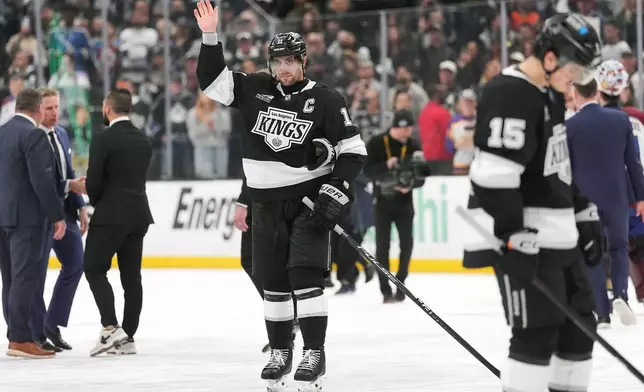 After the final game of his career, Los Angeles Kings' Anze Kopitar, center, waves to the fans following Game 4 in the first round of an NHL hockey Stanley Cup playoff series against the Colorado Avalanche, Sunday, April 26, 2026, in Los Angeles. (AP Photo/Scott Strazzante)