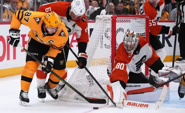 Pittsburgh Penguins' Sidney Crosby (87) cannot shoot against Philadelphia Flyers goaltender Dan Vladar (80) with Flyers' Travis Sanheim (6) defending during the second period of Game 1 in the first round of the NHL Stanley Cup playoffs in Pittsburgh, Saturday, April 18, 2026. (AP Photo/Gene J. Puskar)