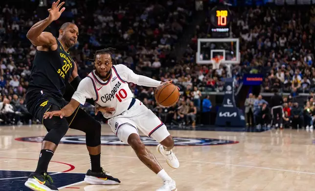 Los Angeles Clippers guard Darius Garland (10) drives against Golden State Warriors center Al Horford (20) during the first half of an NBA basketball game, Sunday, April 12, 2026, in Inglewood, Calif. (AP Photo/Ethan Swope)