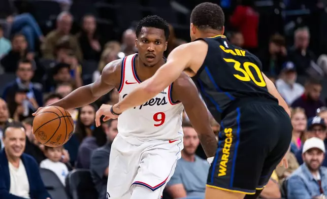 Los Angeles Clippers forward Kawhi Leonard (2) is defended by Golden State Warriors guard Stephen Curry (30) during the first half of an NBA basketball game, Sunday, April 12, 2026, in Inglewood, Calif. (AP Photo/Ethan Swope)