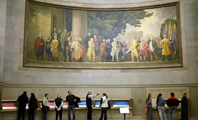 FILE - A large wall mural showing the signing of the Declaration of Independence is seen over visitors at the National Archives, Jan. 29, 2026, in Washington. (AP Photo/John McDonnell, File)