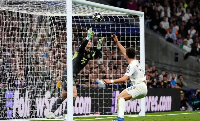 Bayern's goalkeeper Manuel Neuer makes a save before Real Madrid's Raul Asencio can score during the Champions League quarterfinal first leg soccer match between Real Madrid and Bayern Munich in Madrid, Spain, Tuesday, April 7, 2026. (AP Photo/Jose Breton)