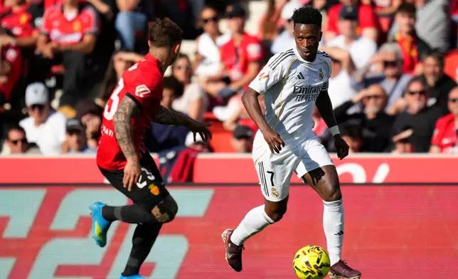 Real Madrid's Vinicius Junior in action in front of Mallorca's Pablo Maffeo during a La Liga soccer match between Mallorca and Real Madrid in Palma de Mallorca, Spain, Saturday, April 4, 2026. (AP Photo/Jose Breton)