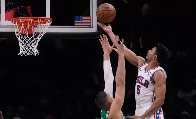 Philadelphia 76ers guard Quentin Grimes (5) drives to the basket against Boston Celtics center Nikola Vucevic (4) during the first half of Game 2 of a first-round NBA playoffs basketball series, Tuesday, April 21, 2026, in Boston. (AP Photo/Charles Krupa)