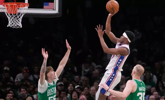 Philadelphia 76ers guard Vj Edgecombe takes a shot against Boston Celtics guard Baylor Scheierman (55) and forward Sam Hauser (30) during the first half of Game 2 of a first-round NBA playoffs basketball series, Tuesday, April 21, 2026, in Boston. (AP Photo/Charles Krupa)