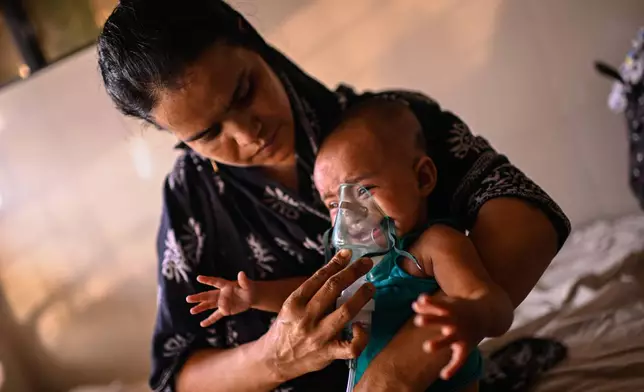 A mother administers a nebulizer treatment for her child suffering from measles at the Infectious Diseases Hospital in Dhaka, Bangladesh, Monday, April 6, 2026, amid a countrywide outbreak. (AP Photo/Mahmud Hossain Opu)