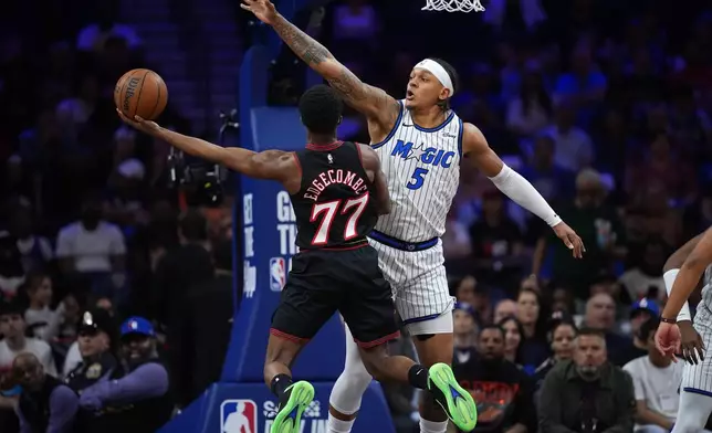 Philadelphia 76ers' Vj Edgecombe, left, goes up for a shot against Orlando Magic's Paolo Banchero during the first half of an NBA play-in tournament basketball game Wednesday, April 15, 2026, in Philadelphia. (AP Photo/Matt Slocum)