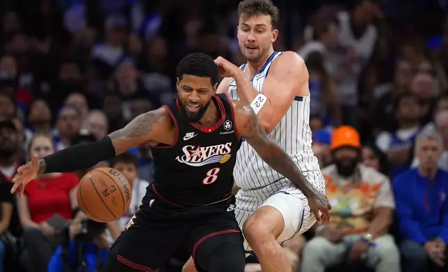 Philadelphia 76ers' Paul George, left, tries to get past Orlando Magic's Franz Wagner during the first half of an NBA play-in tournament basketball game Wednesday, April 15, 2026, in Philadelphia. (AP Photo/Matt Slocum)