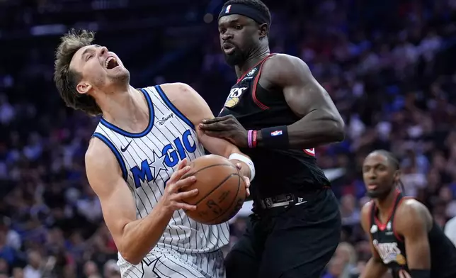 Orlando Magic's Franz Wagner, left, is fouled by Philadelphia 76ers' Adem Bona during the first half of an NBA play-in tournament basketball game Wednesday, April 15, 2026, in Philadelphia. (AP Photo/Matt Slocum)