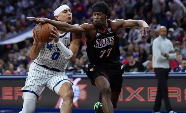 Orlando Magic's Anthony Black, left, tries to get past Philadelphia 76ers' Vj Edgecombe during the first half of an NBA play-in tournament basketball game Wednesday, April 15, 2026, in Philadelphia. (AP Photo/Matt Slocum)