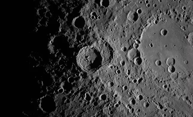 In this image provided by NASA, the Artemis II crew captured this image of the Vavilov Crater on the Moon during a lunar flyby, Monday, April 6, 2026. NASA via AP)
