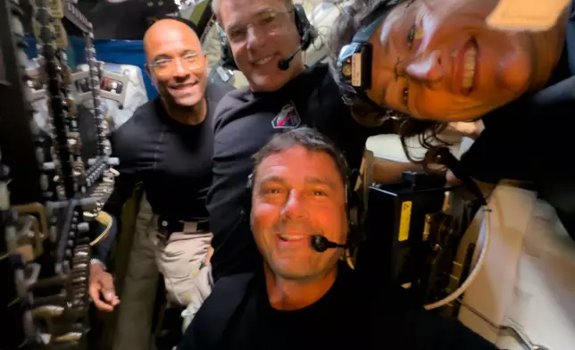 In this image provided by NASA, Artemis II crew members, from left, Victor Glover Jeremy Hansen, Victor Glover, Reid Wiseman and Christina Koch, pause to turn the camera around for a selfie midway through their lunar observation period of the Moon during a lunar flyby, Monday, April 6, 2026. NASA via AP)
