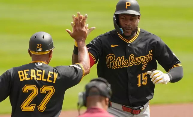 Pittsburgh Pirates' Oneil Cruz (15) celebrates with third base coach Tony Beasley (27) as he rounds the bases after hitting a three-run homer in the first inning of a baseball game against the Cincinnati Reds in Cincinnati, Wednesday, April 1, 2026. (AP Photo/Carolyn Kaster)