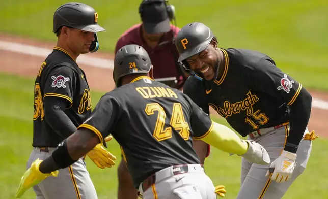 Pittsburgh Pirates' Oneil Cruz, right, celebrates with Marcell Ozuna, center, and Nick Yorke, left, after hitting a three-run homer in the first inning of a baseball game against the Cincinnati Reds in Cincinnati, Wednesday, April 1, 2026. (AP Photo/Carolyn Kaster)