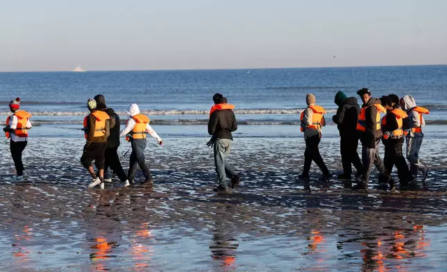 Migrants board a small boat in an attempt to reach Britain, Wednesday, April 8, 2026 in Malo-les-Bains, northern France. (AP Photo/Jean-Francois Badias)