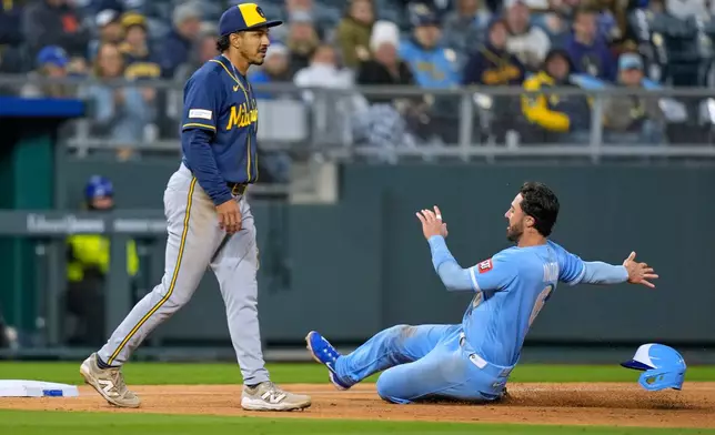 Kansas City Royals' Jonathan India, right, beats the tag by Milwaukee Brewers third baseman David Hamilton to advance to third on a single by Carter Jensen during the sixth inning in the second baseball game of a doubleheader Saturday, April 4, 2026, in Kansas City, Mo. (AP Photo/Charlie Riedel)